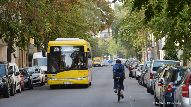 Ein Bus fährt an einem entgegenkommenden Radfahrer vorbei